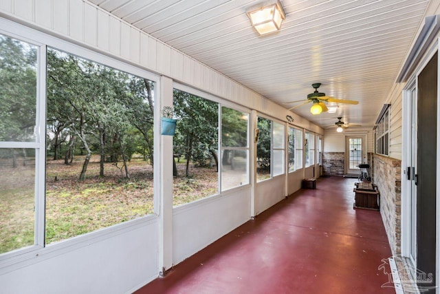 unfurnished sunroom with ceiling fan