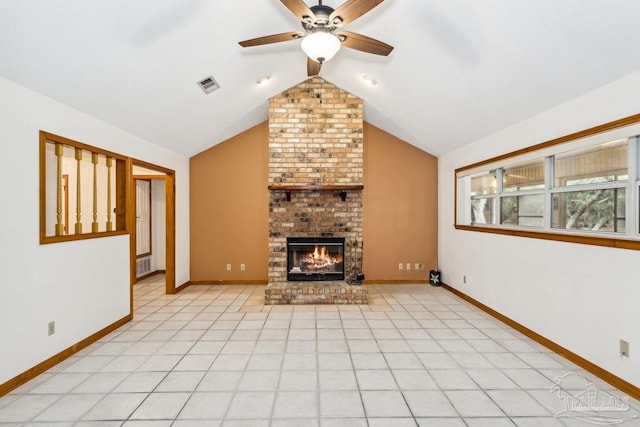 unfurnished living room with a brick fireplace, ceiling fan, light tile patterned floors, and vaulted ceiling