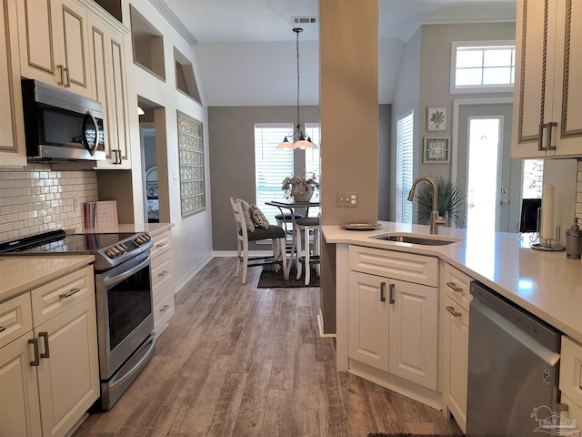 kitchen with stainless steel appliances, dark wood-style flooring, light countertops, and a sink