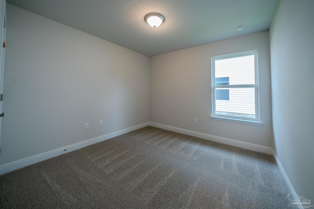 spare room featuring baseboards and carpet