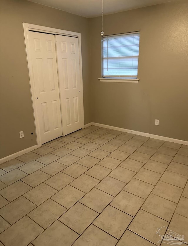907 Colbert Ave, Pensacola, FL 32507 - unfurnished bedroom featuring a closet and light tile patterned floors