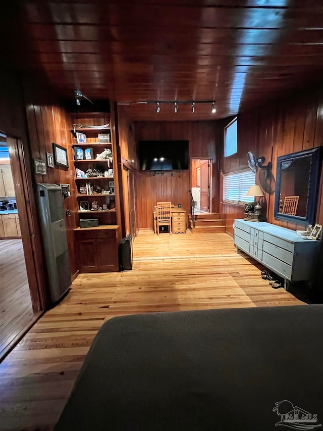 living room with track lighting, wood ceiling, light wood-type flooring, and built in shelves