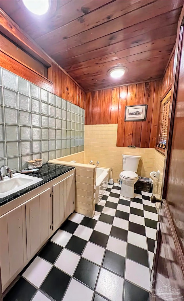 bathroom featuring a tub, vanity, toilet, and wood ceiling