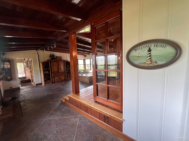 hall with vaulted ceiling with beams and plenty of natural light