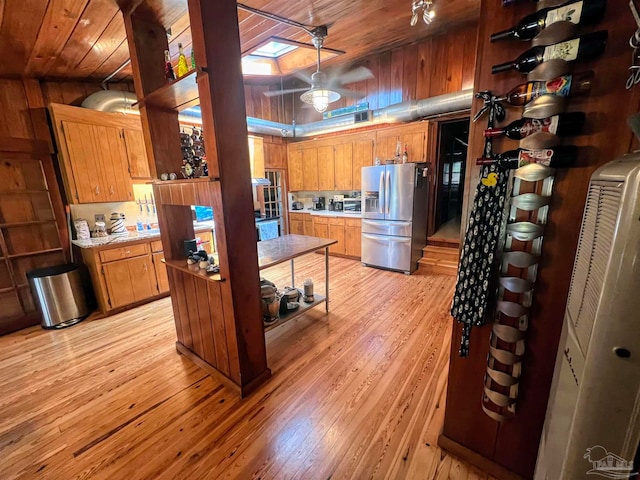 kitchen featuring pendant lighting, wood ceiling, stainless steel fridge with ice dispenser, and light hardwood / wood-style flooring