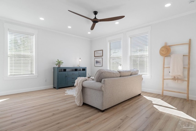 living area with plenty of natural light, light wood-type flooring, crown molding, and baseboards