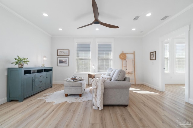 living area with a wealth of natural light, visible vents, and crown molding