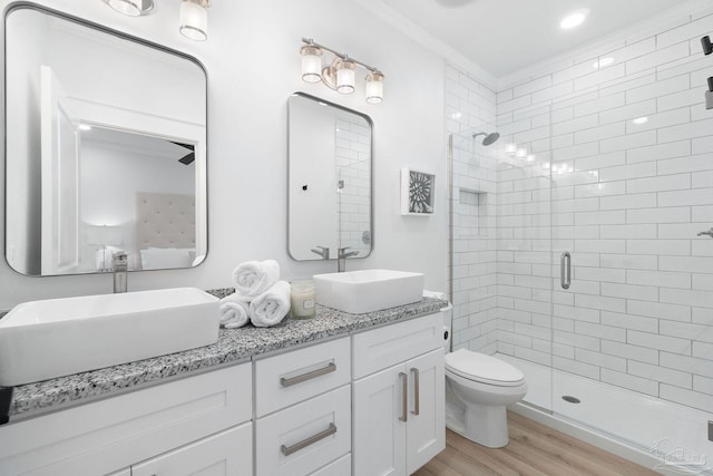 full bathroom with a sink, toilet, a stall shower, and wood finished floors