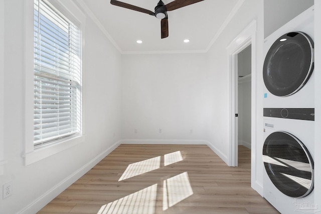 washroom with light wood-style flooring, stacked washer and clothes dryer, baseboards, and ornamental molding