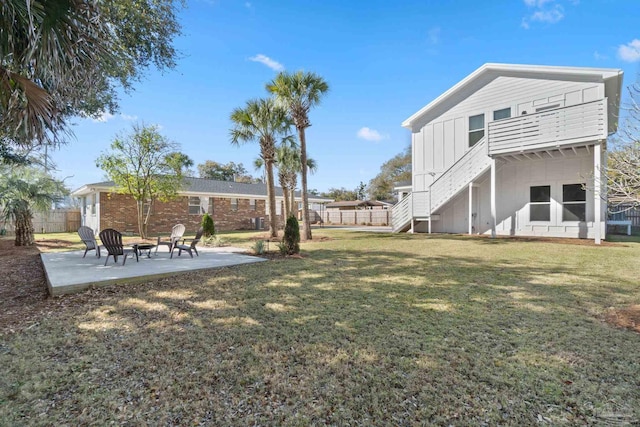 view of yard with stairs, a patio, and fence