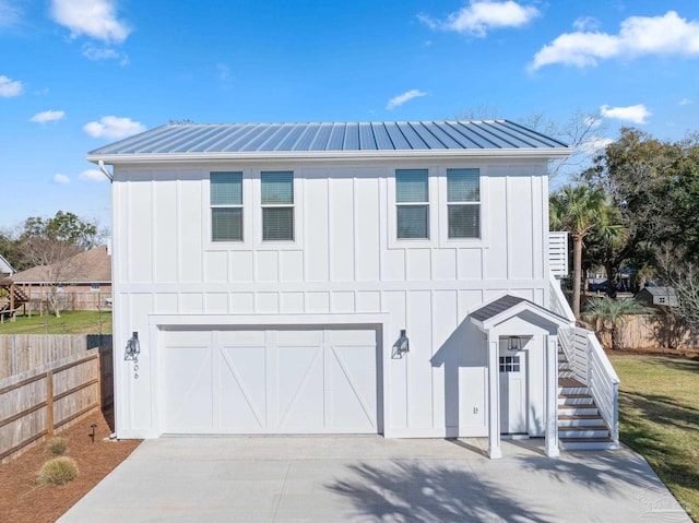 view of front of house featuring stairway, board and batten siding, metal roof, and concrete driveway