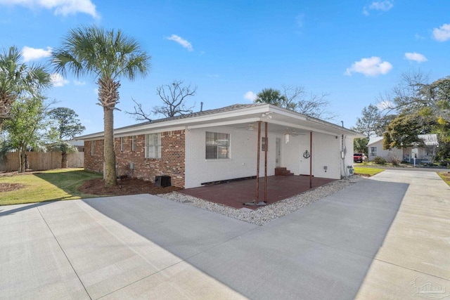 ranch-style home featuring brick siding, a front lawn, and fence