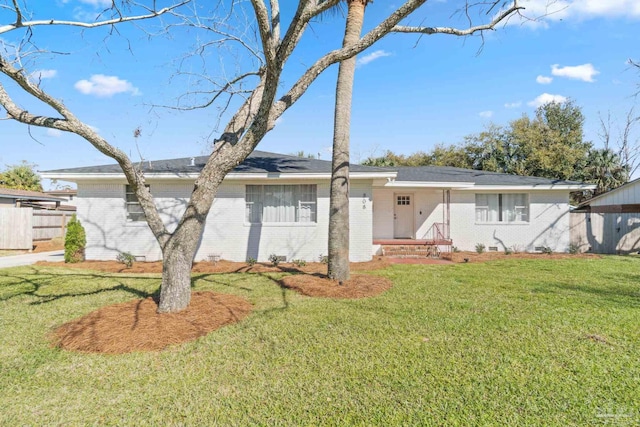 view of front of house featuring a front lawn, fence, and brick siding