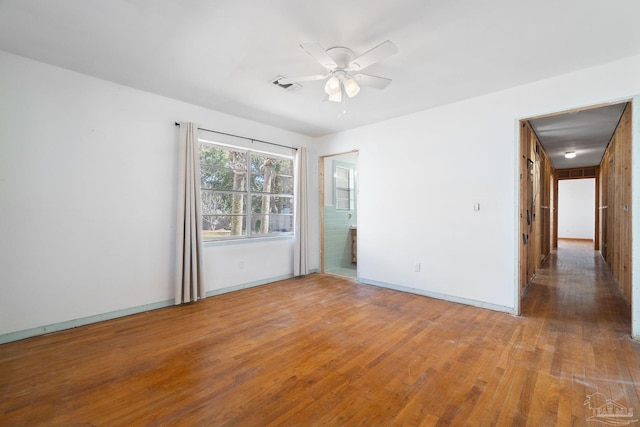 spare room with visible vents, baseboards, ceiling fan, and wood finished floors