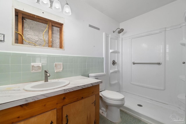 bathroom with a wainscoted wall, toilet, tile walls, a shower stall, and vanity