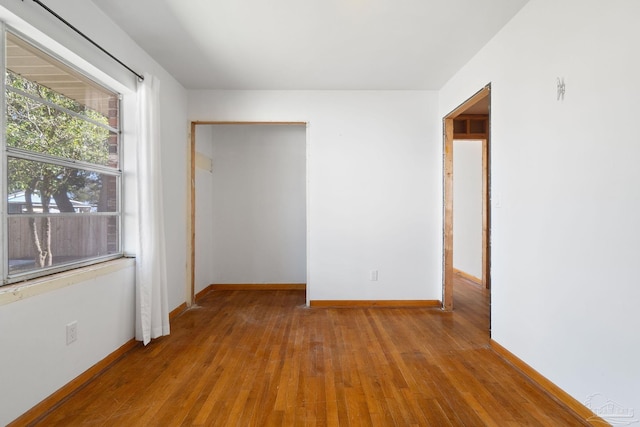 unfurnished room featuring baseboards and hardwood / wood-style floors