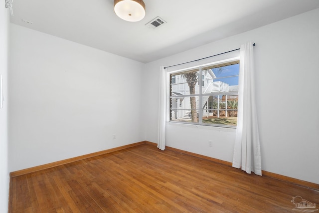 unfurnished room featuring light wood-style floors, visible vents, and baseboards