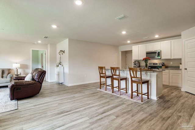 3488 Fallschase Blvd, Pensacola, FL 32526 - kitchen featuring appliances with stainless steel finishes, open floor plan, light wood-style flooring, white cabinets, and recessed lighting