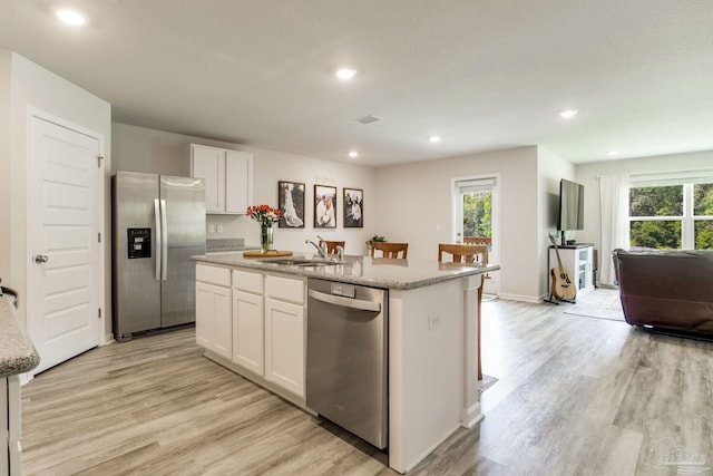 3488 Fallschase Blvd, Pensacola, FL 32526 - kitchen with stainless steel appliances, light wood-style flooring, a center island with sink, white cabinets, and recessed lighting
