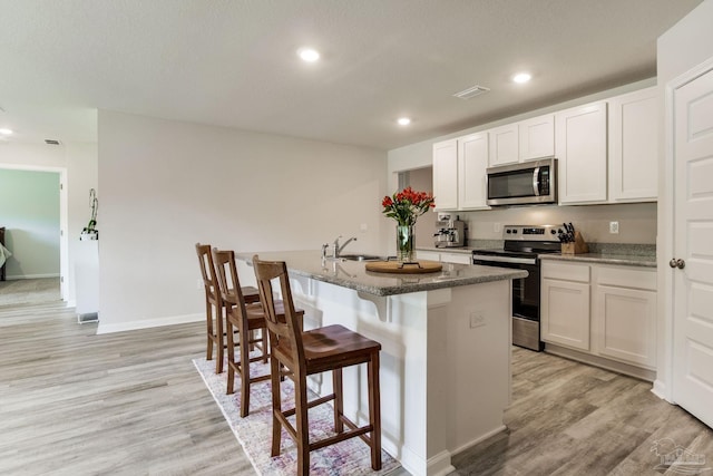 3488 Fallschase Blvd, Pensacola, FL 32526 - kitchen featuring stainless steel appliances, light wood-type flooring, an island with sink, a sink, and recessed lighting