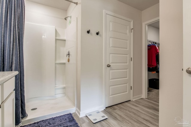 3488 Fallschase Blvd, Pensacola, FL 32526 - bathroom with a stall shower, wood finished floors, a spacious closet, and baseboards