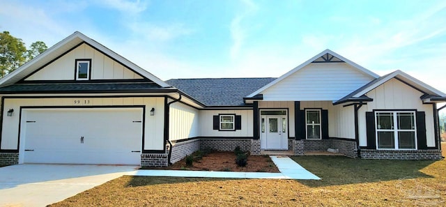 view of front of house featuring an attached garage, brick siding, concrete driveway, board and batten siding, and a front yard