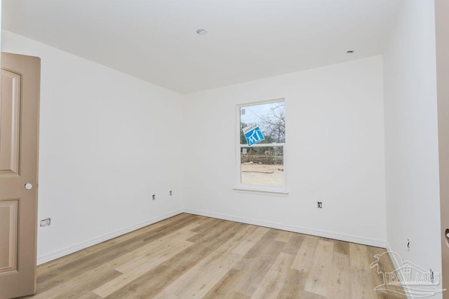 spare room with light wood-style floors and baseboards