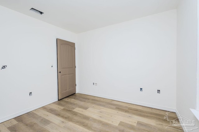 spare room with light wood-type flooring and baseboards