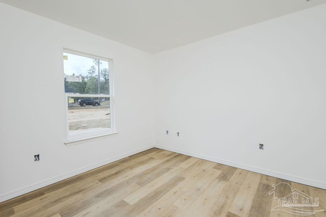 empty room with baseboards and wood finished floors