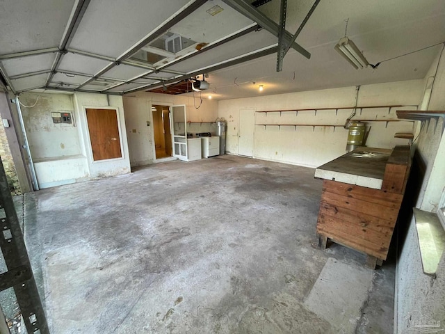 garage featuring a garage door opener, electric water heater, and washing machine and clothes dryer