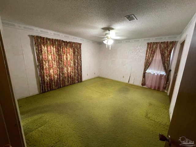 unfurnished room featuring ceiling fan, a textured ceiling, and carpet floors