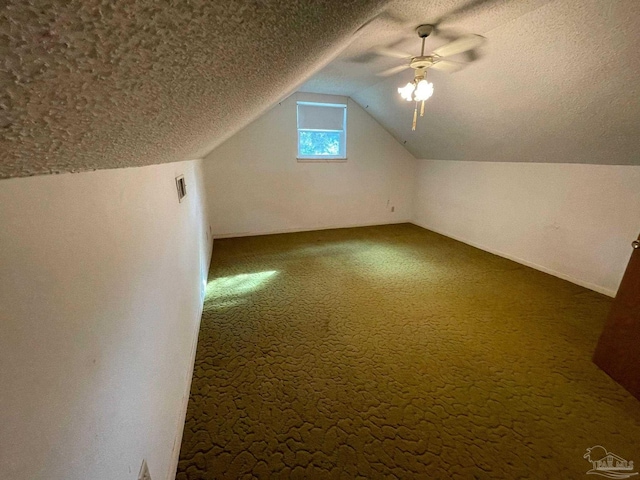 bonus room with carpet flooring, lofted ceiling, a textured ceiling, and ceiling fan