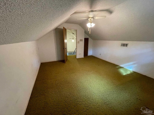 additional living space featuring lofted ceiling, a textured ceiling, and ceiling fan