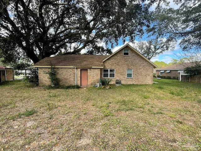 back of house with a lawn and central AC