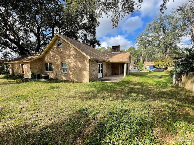 rear view of house with a patio and a yard