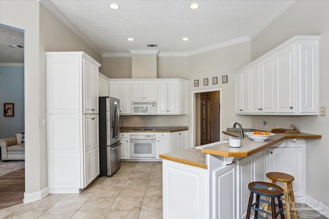 2520 Abbie Elizabeth Ct, Gulf Breeze, FL 32563 - kitchen featuring white appliances, a peninsula, a breakfast bar, white cabinetry, and crown molding