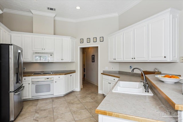 2520 Abbie Elizabeth Ct, Gulf Breeze, FL 32563 - kitchen with white appliances, ornamental molding, white cabinetry, and light tile patterned flooring