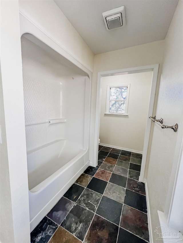 bathroom with stone finish floor, visible vents, baseboards, and toilet