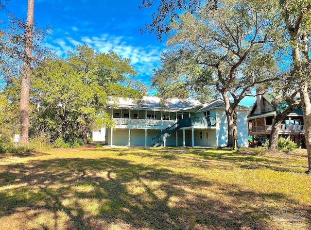 rear view of house with a yard, a deck, and stairs