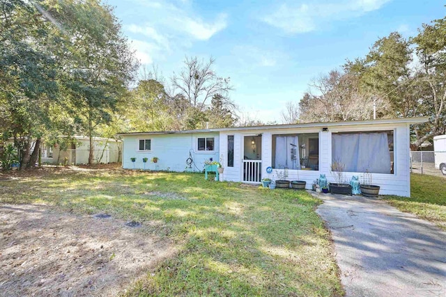 ranch-style home with a front yard and fence