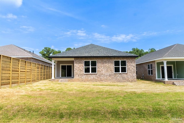 rear view of house featuring a lawn