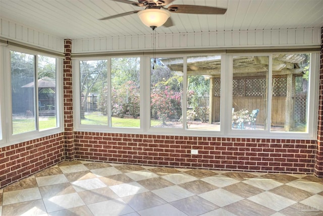 unfurnished sunroom featuring ceiling fan