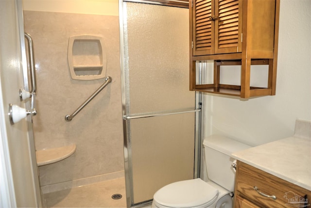 bathroom with vanity, toilet, and a shower with door