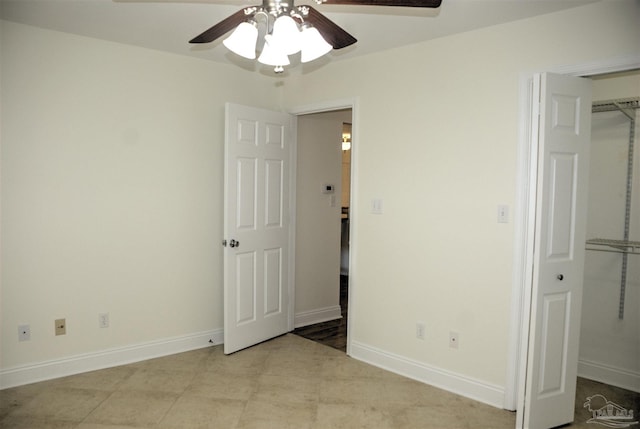 unfurnished bedroom with ceiling fan, a spacious closet, and a closet