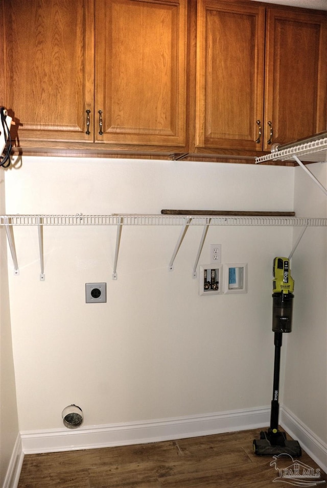 laundry room featuring electric dryer hookup, washer hookup, dark wood-type flooring, and cabinets