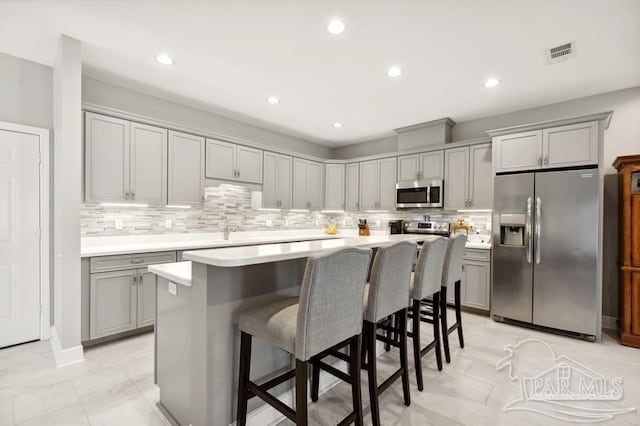 kitchen featuring a center island, backsplash, and stainless steel appliances