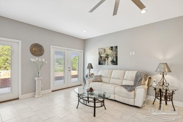 tiled living room featuring french doors and ceiling fan