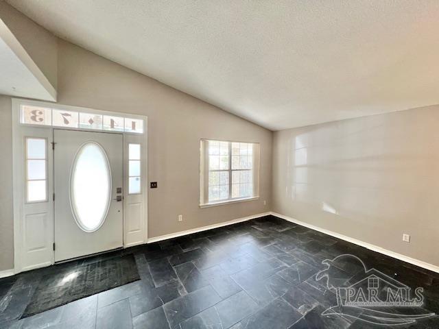 entryway with lofted ceiling and a textured ceiling