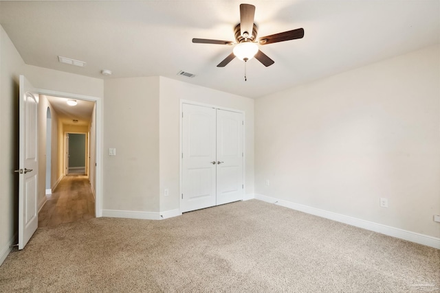 unfurnished bedroom with baseboards, carpet, visible vents, and a closet