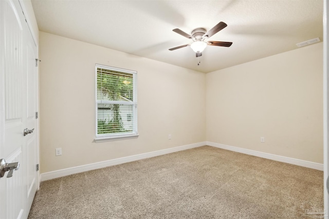 empty room featuring visible vents, ceiling fan, light carpet, and baseboards